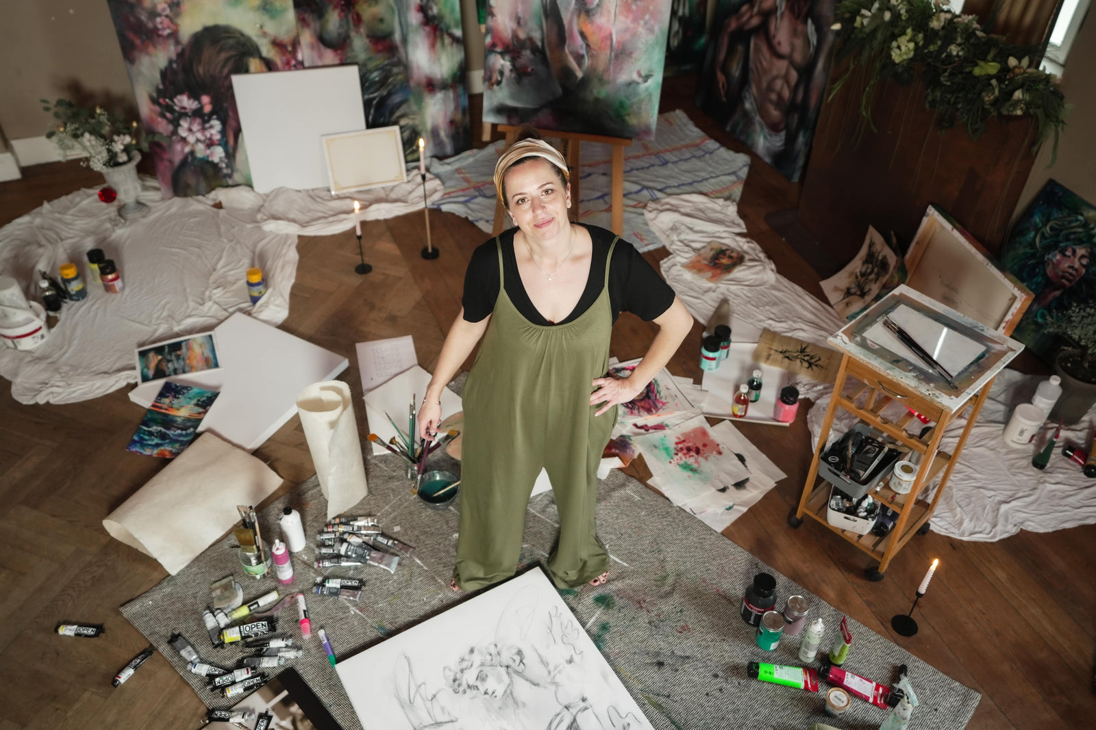 Portrait von Katharina Hindes: sie blickt in die Kamera, im Hintergrund die getönten Wände des Ateliers.